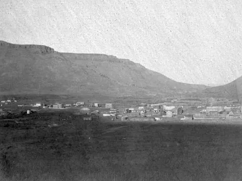 Archival photograph: Golden in 1868, a scatter of buildings on the flat below the mesas