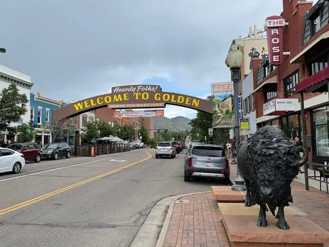 Washington Avenue at 12th Street in downtown Golden, June 2021: the Welcome to Golden arch over the street and a bronze bison on the corner