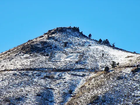Mount Zion, the paraglider launch above the Windy Saddle trailhead, under light snow with the Colorado School of Mines M on its slope